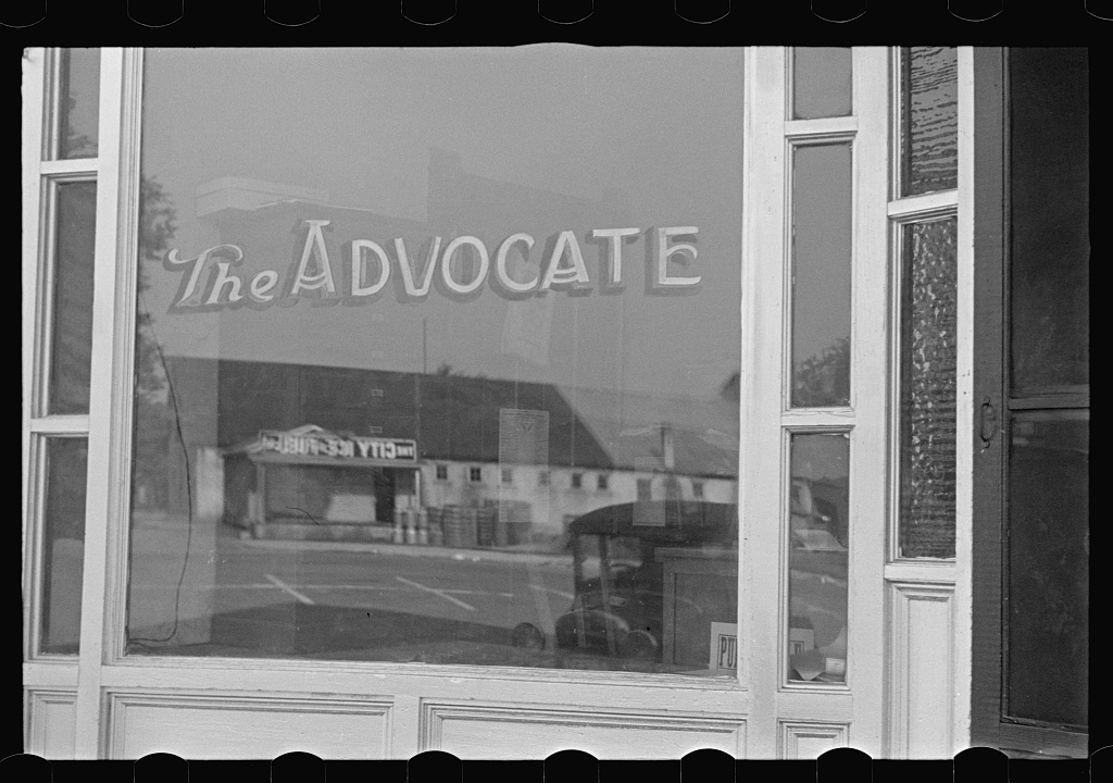 Public domain photograph of a small-town newspaper office with desks and editorial workflow materials.